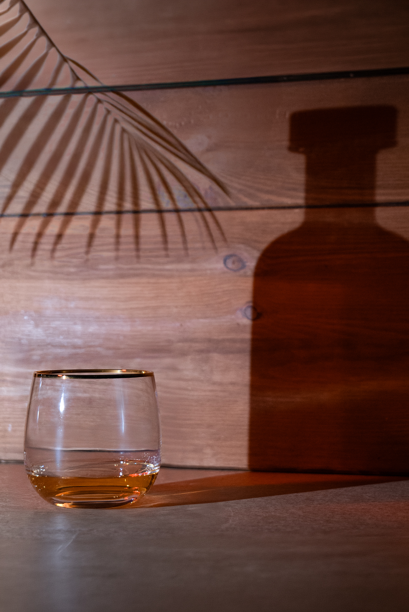 Rum im Glas mit Flasche als Schatten