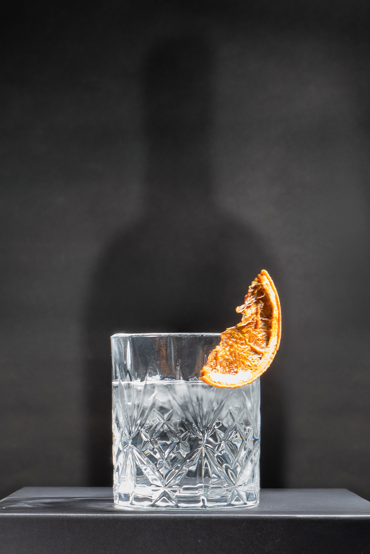 Ein Glas gefüllt mit Gin und einer Orangenscheibe.
