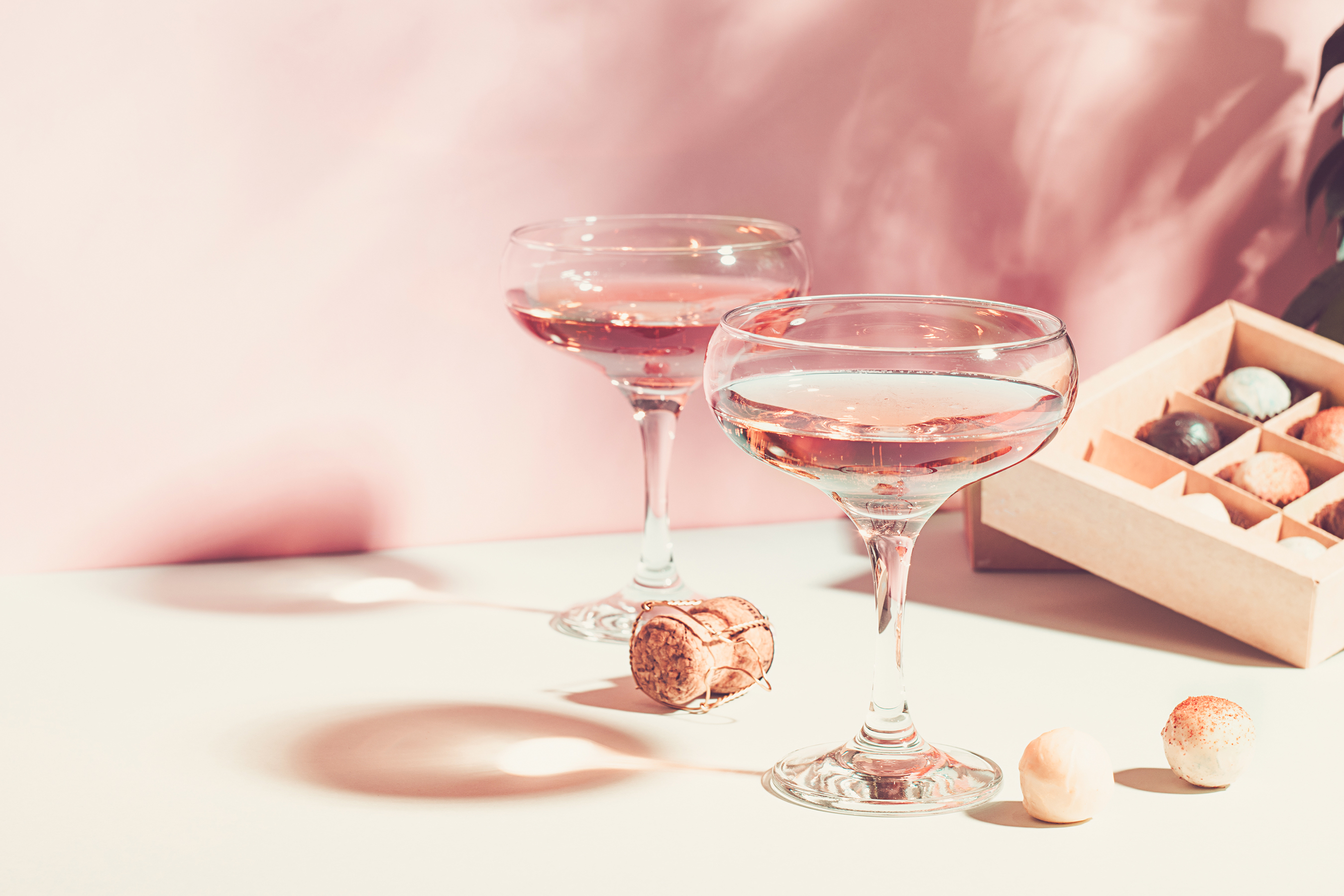 Schaumwein in einer Coupette mit Pralinen.