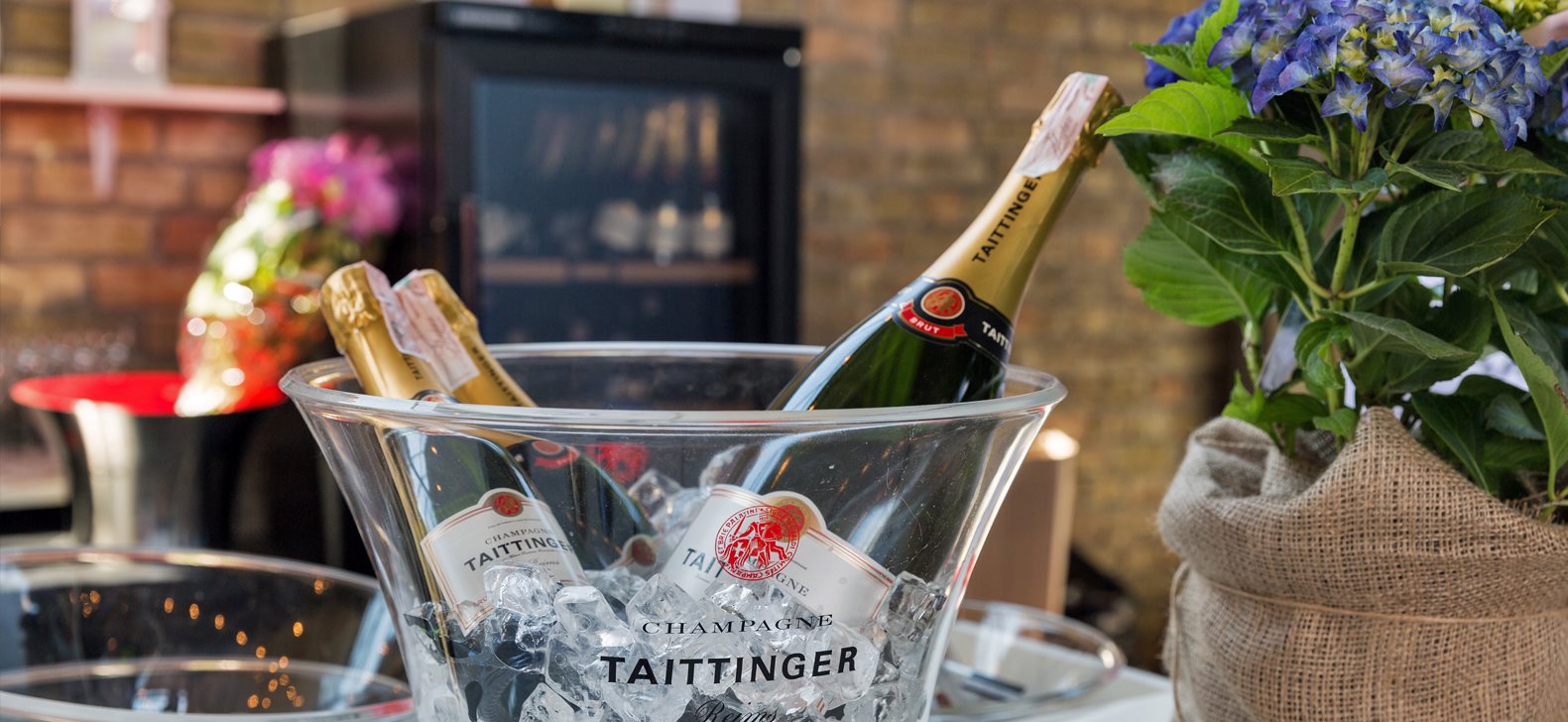 Taittinger Champagner, Eiskübel und Blumen