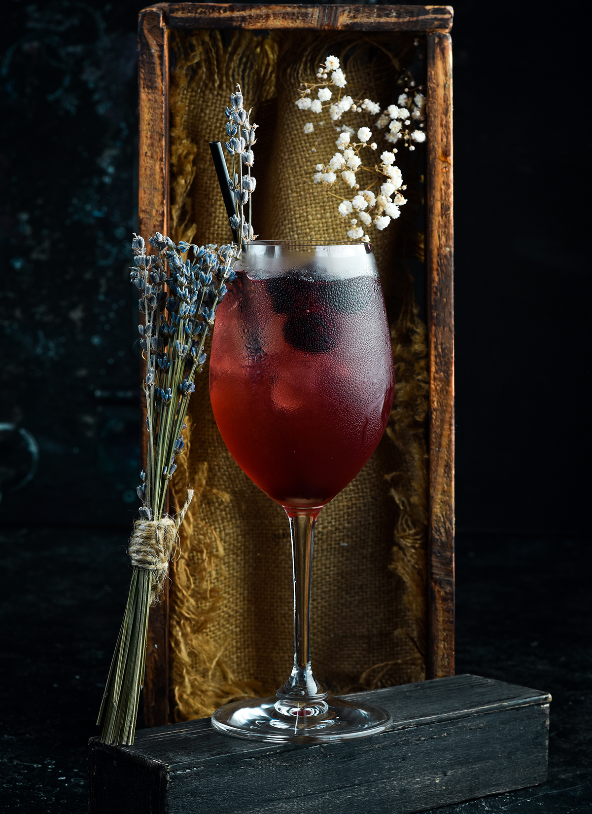 Ein gefülltes Weinglas mit einem Bramble Gin Cocktail.
